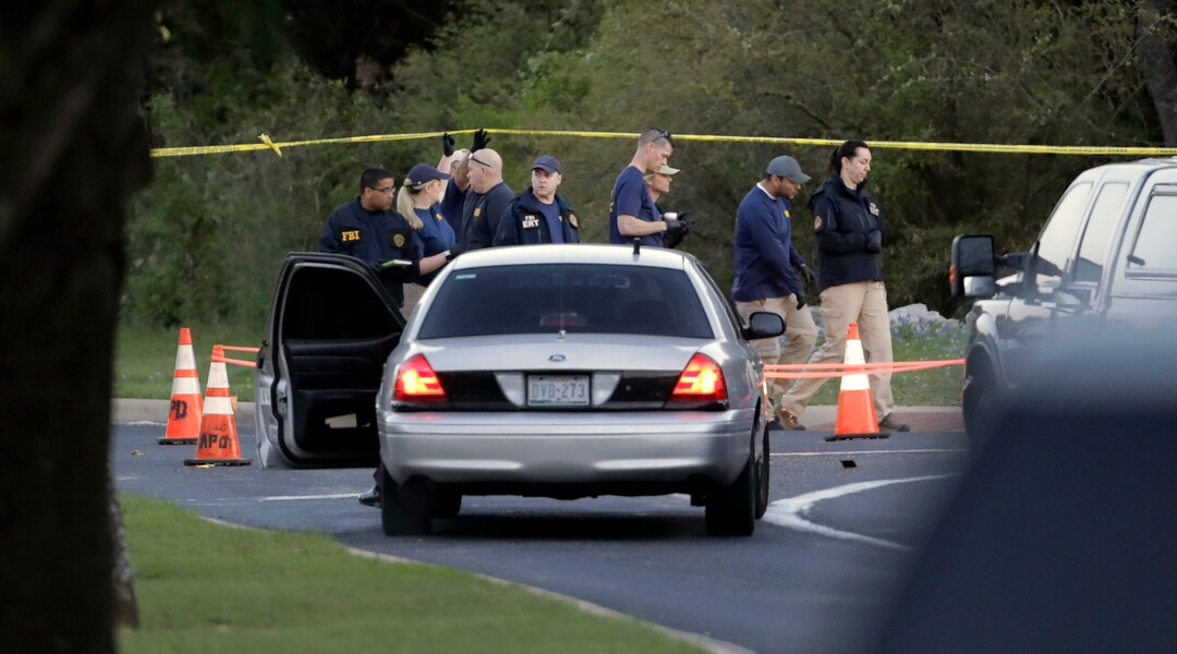 Officials work and stage near the site of Sunday's deadly explosion, Monday, March 19, 2018, in Austin, Texas. Police warned nearby residents to remain indoors overnight as investigators looked for possible links to other package bombings elsewhere in the city this month. (AP Photo/Eric Gay)