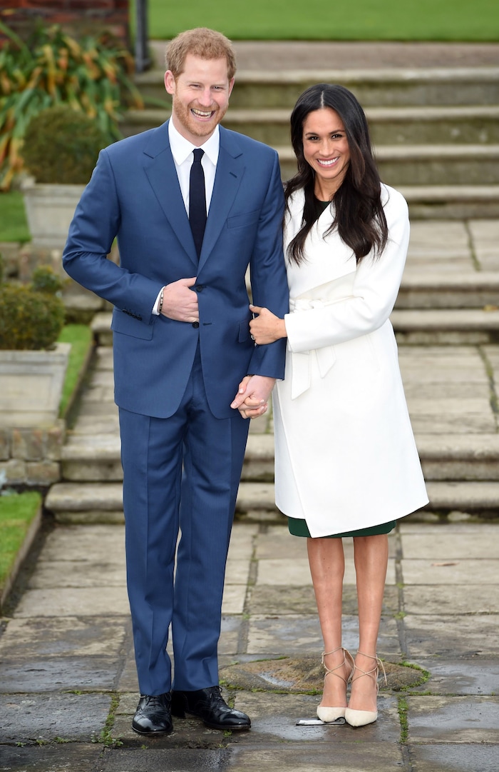 Britain's Prince Harry and Meghan Markle pose for the media in the grounds of Kensington Palace in London, Monday Nov. 27, 2017. It was announced Monday that Prince Harry, fifth in line for the British throne, will marry American actress Meghan Markle in the spring, confirming months of rumors. (Eddie Mulholland/Pool via AP)