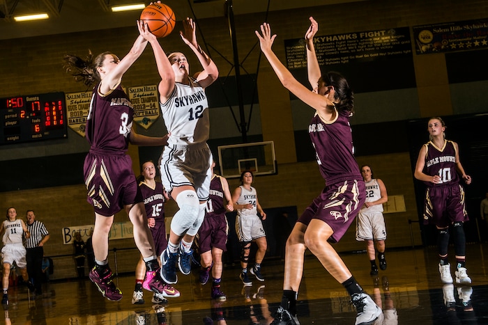 Chris Detrick  |  The Salt Lake TribuneSalem Hills' Lauren Gustin (12) shoots past Maple Mountain's MiKayla Hubbard (34) and Maple Mountain's Nicole Heyn (3) during the game at Salem Hills High School Tuesday January 12, 2016. Salem Hills won the game 82-63.