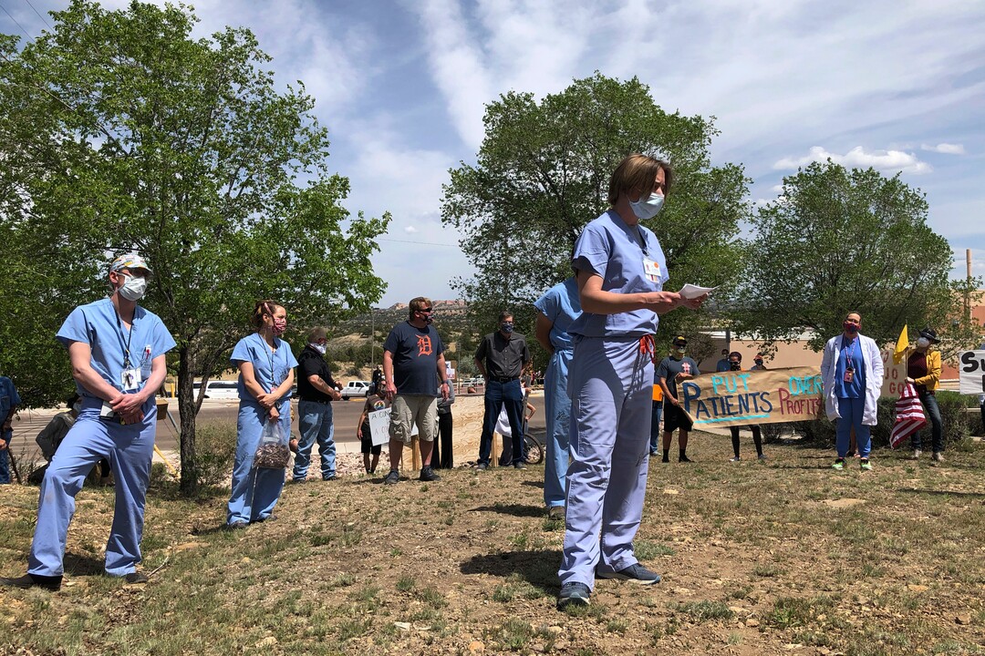 In this photo taken May 8, 2020, medical staff from Rehoboth McKinley Christian Hospital including Chief Medical Officer Val Wangler, center, hold a protest over working conditions and depleted staff in Gallup, N.M. Many nurses and doctors say staffing at the hospital was inadequate because of hospital CEO David Conejo's move to cut back on nurses in the first week of March to offset declining hospital revenues after elective surgeries were suspended. They voiced their discontent at the recent protest calling for his resignation. (AP Photo/Morgan Lee)