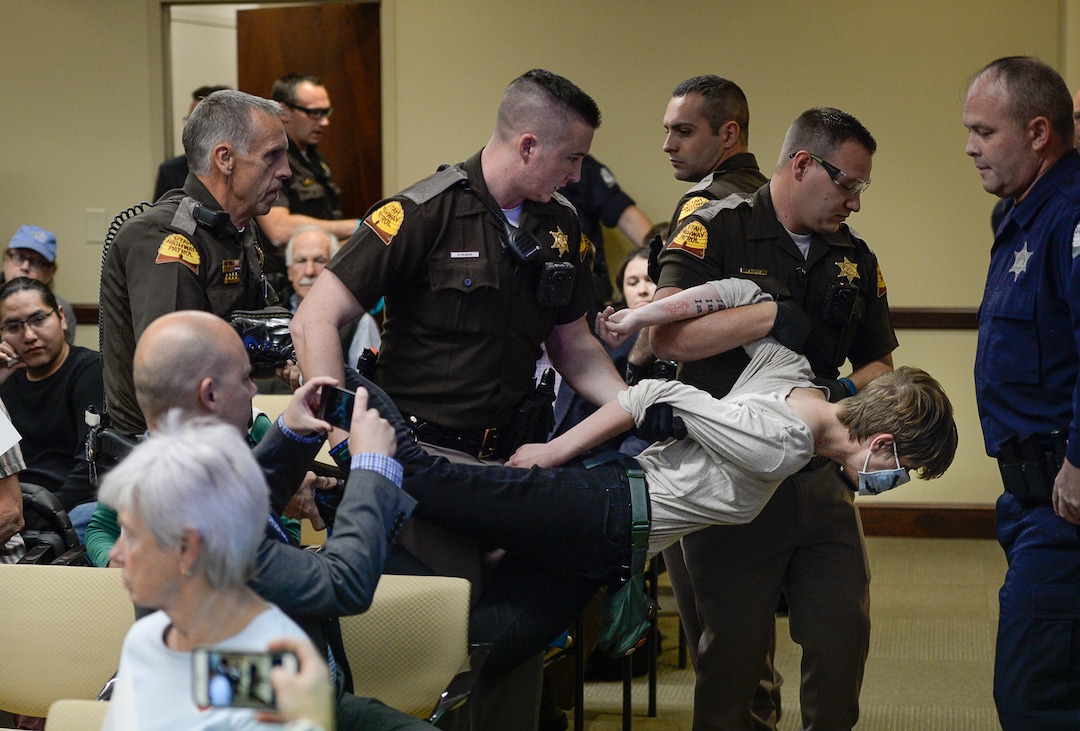 (Francisco Kjolseth  |  The Salt Lake Tribune)  Utah Highway Patrol troopers remove a woman blowing a whistle through a surgical mask as the Utah Inland Port Authority meets for the first time since its June meeting was disrupted by protestors at the Utah Capitol on Thursday, Oct. 17, 2019.
