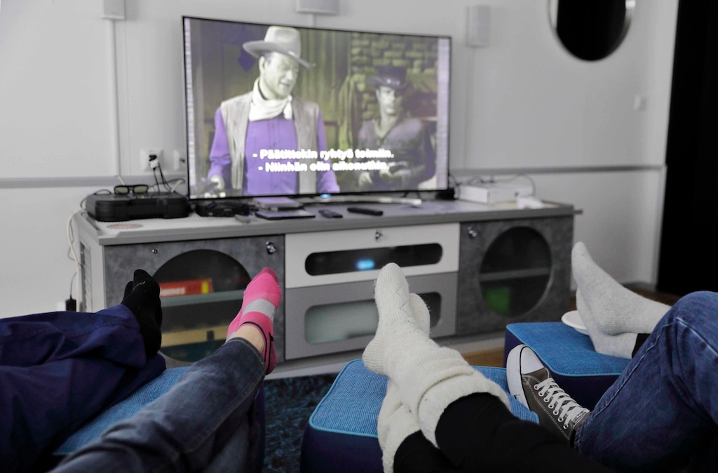 In this Saturday, July 15, 2017, photo, researchers aboard the Finnish icebreaker MSV Nordica put their feet up while watching the movie "El Dorado" starring John Wayne as the ship sails the Chukchi Sea to traverse the Northwest Passage through the Canadian Arctic Archipelago. (AP Photo/David Goldman)