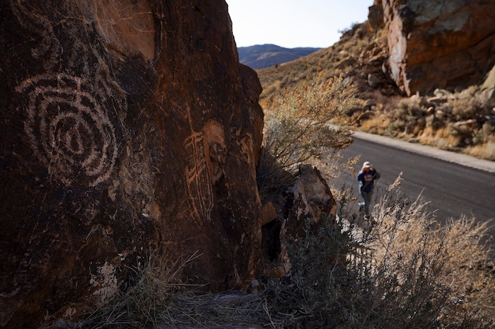(Leah Hogsten | The Salt Lake Tribune) A visitor to the Parowan Gap, March 20, 2021. Researchers believe that the petroglyphs written into the Navajo sandstone at Parowan Gap were pecked and scratched by Native Americans who were living and farming in the Parowan Valley around 500 A.D., a time period archaeologists call the Fremont period. The Fremont Indians are closely related to the modern-day Hopi and Piute tribes and the Parowan Gap is a sacred site for both tribes.