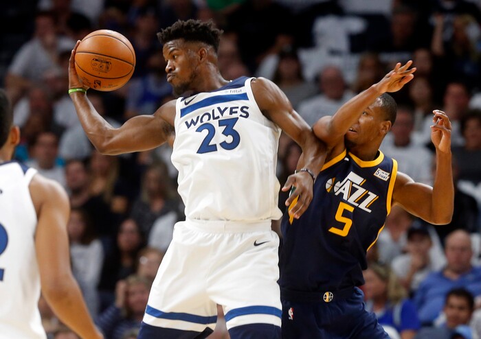 Minnesota Timberwolves' Jimmy Butler (23) grabs a pass in front of Utah Jazz's Rodney Hood during the first half of an NBA basketball game Friday, Oct. 20, 2017, in Minneapolis. (AP Photo/Jim Mone)