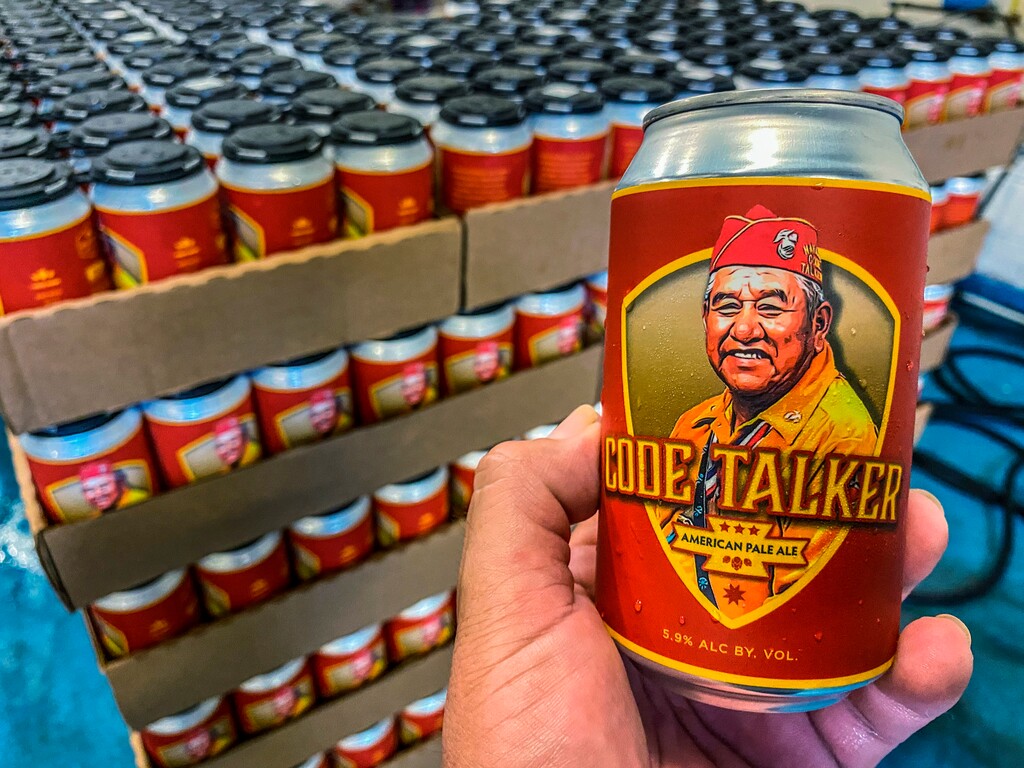 (LT Goodluck via AP) In this Aug. 14, 2020, photo courtesy of LT Goodluck, LT Goodluck holds a beer can honoring his grandfather, Navajo Code Talker John V. Goodluck at the Hellbender Brewing Co., in Washington, D.C. In honor of National Navajo Code Talkers Day the craft brewery recently rereleased its Code Talker American Pale Ale , this time in a can, drawing some rave reviews but also backlash. The beer was formulated and brewed by Goodluck in honor of his late grandfather and Navajo Code Talker John V. Goodluck.