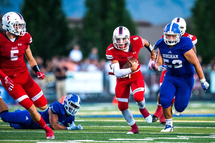 (Chris Detrick  |  The Salt Lake Tribune)  East's Ben Ford (8) runs past Bingham's Amanaki Angilau (52) during the game at Bingham High School Friday, August 25, 2017. Bingham is winning the game 24-17 at halftime. 