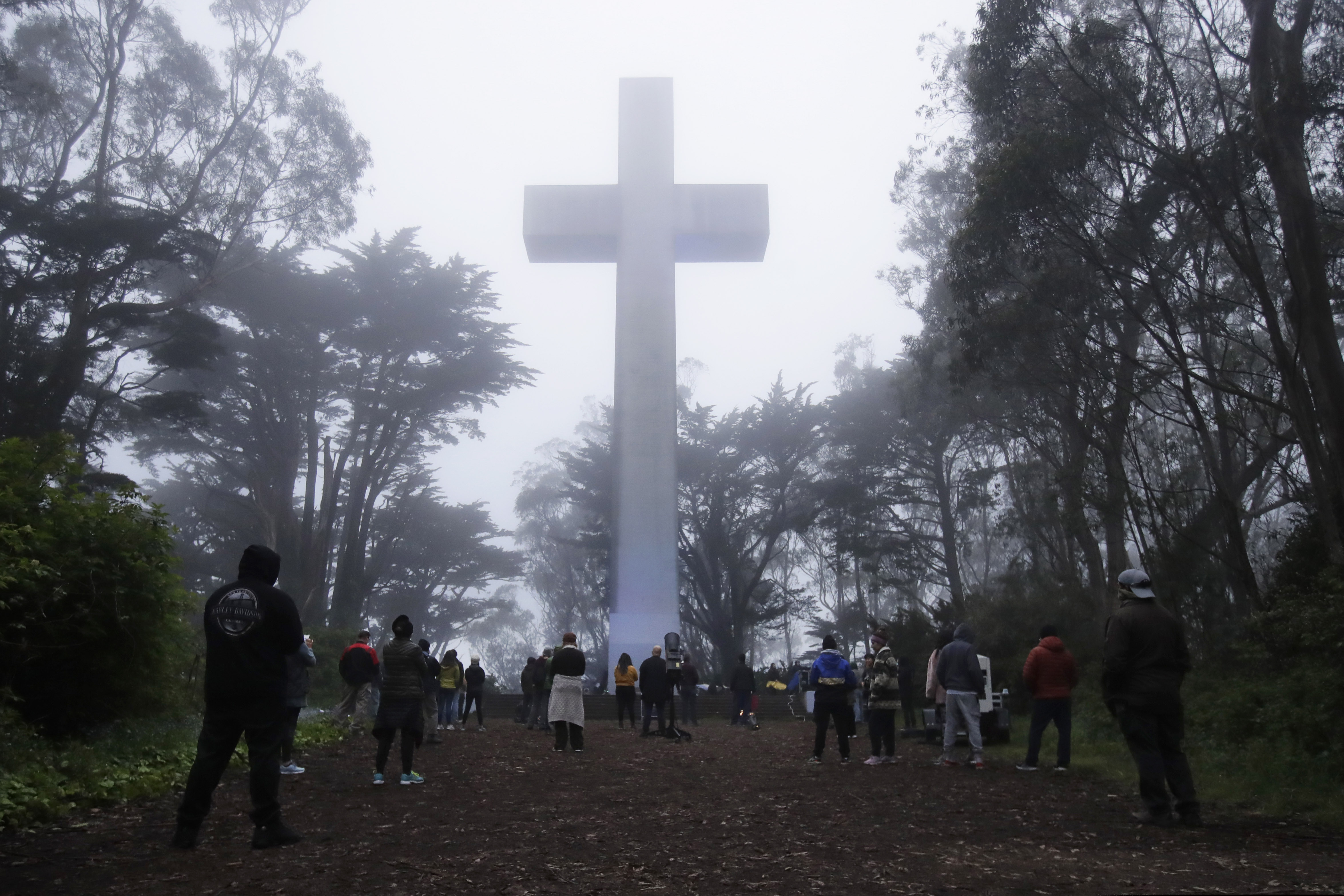 Jeff Chiu | The Associated Press) People gather at the Mount Davidson cross in San Francisco, Sunday, April 12, 2020. Mount Davidson's annual Easter Sunrise Service was canceled for San Francisco's shelter in place orders over coronavirus concerns.