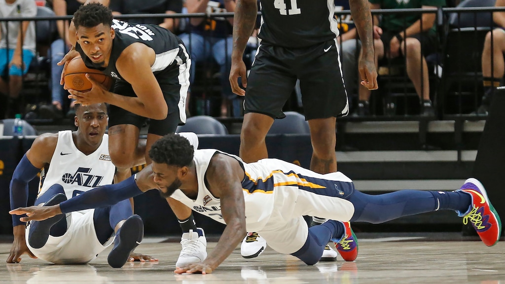 San Antonio Spurs forward Ben Moore, center, recovers a loose ball as Utah Jazz's Willie Reed, foreground, and Miye Oni, rear, defend during the second half of an NBA summer league basketball game Wednesday, July 3, 2019, in Salt Lake City. (AP Photo/Rick Bowmer)
