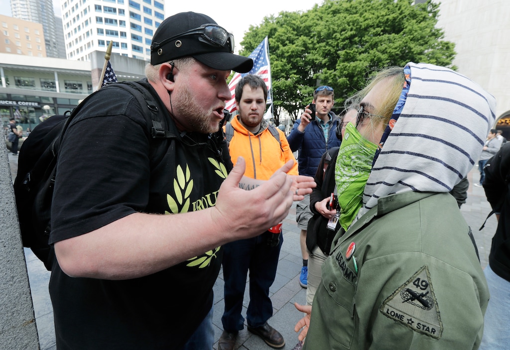 Travis, left, who only gave his first name, a member of the Proud Boys group, argues with Cassidy Newnark during a May Day rally, Tuesday, May 1, 2018, in Seattle. (AP Photo/Ted S. Warren)