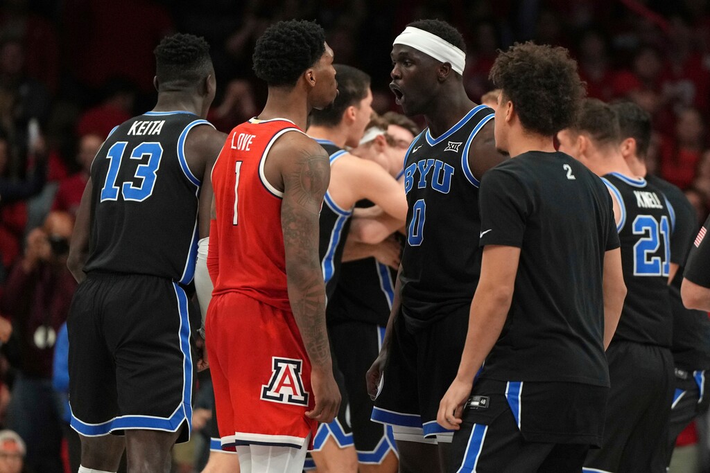 (Rick Scuteri | AP) Arizona guard Caleb Love (1) and BYU forward Mawot Mag (0) talk to each other during the second half of an NCAA college basketball game, Saturday, Feb. 22, 2025, in Tucson, Ariz. BYU won 96-95.