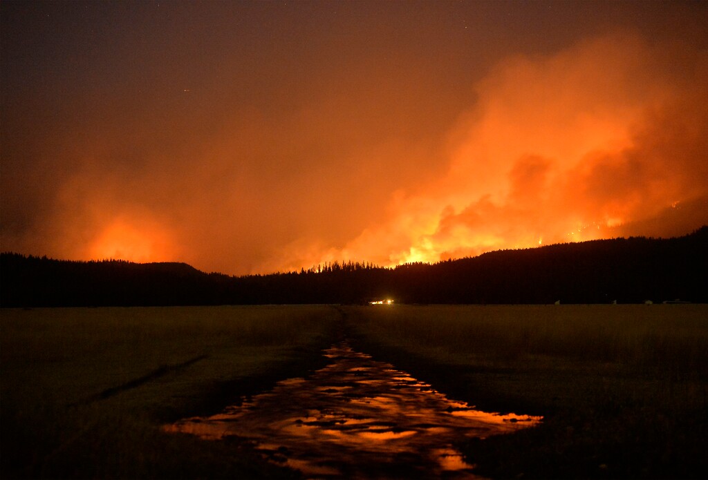 (Rion Sanders | The Great Falls Tribune | The Associated Press) In an Aug. 31, 2017 photo, the Rice Ridge Fire burns in the Lolo National Forest near Woodworth Road northeast of Salmon Lake, Mont. The smoke from massive wildfires hangs like fog over large parts of the U.S. West, an irritating haze causing health concerns, forcing sports teams to change schedules and disrupting life from Seattle to tiny Seeley Lake, Montana.