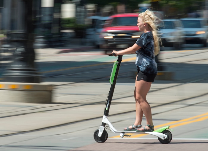 (Rick Egan  |  The Salt Lake Tribune)   A woman rides a Lime Scooter, in downtown Salt Lake City, Monday, July 30, 2018.

 