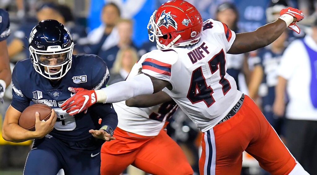 Utah State quarterback Henry Colombi (3) carries the ball as Stony Brook linebacker Elijah Duff (47) defends during an NCAA college football game, Saturday, Sept. 7, 2019, in Logan, Utah. (Eli Lucero/The Herald Journal via AP)