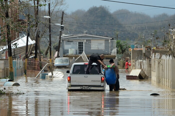 Residents evacuate after the passing of Hurricane Maria, in Toa Baja, Puerto Rico, Friday, September 22, 2017. Because of the heavy rains brought by Maria, thousands of people were evacuated from Toa Baja after the municipal government opened the gates of the Rio La Plata Dam. (AP Photo/Carlos Giusti)