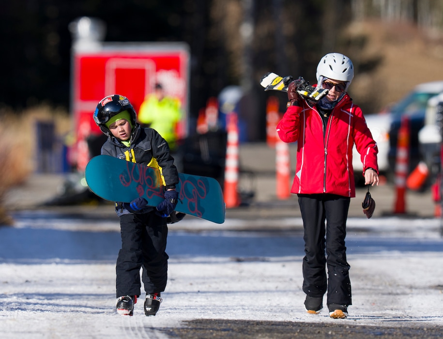 (Bethany Baker  |  The Salt Lake Tribune) Teddy Martini, 8, carries his snowboard beside his mother Rachelle Martini, both from San Diego, during opening day at Solitude Mountain Resort in Brighton on Thursday, Nov. 27, 2025.