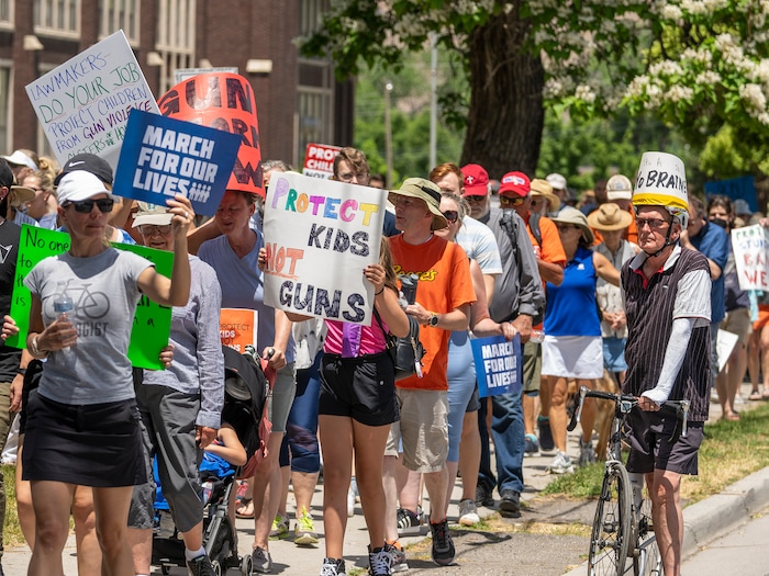 (Leah Hogsten | The Salt Lake Tribune) Dr. Albert Hartman, right, wears a poster on his bike helmet that reads "This is a no brainer" as hundreds of Utahns marched from West High School to the Capitol, Saturday, June 11, 2022, during the March For Our Lives SLC event. The march is in response to the most recent shootings in Uvalde, Buffalo and Tulsa to demand action from Utah legislators and congressmen to enact gun safety laws.