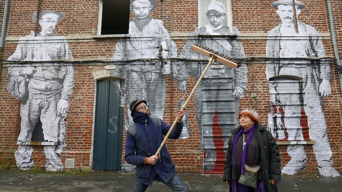 (Photo courtesy of Cohen Media Group) French filmmaker Agnes Varda (right) and Paris street artist JR stand in front of abandoned coal miners' homes, on which JR has plastered old photos of miners, in the documentary "Faces Places."