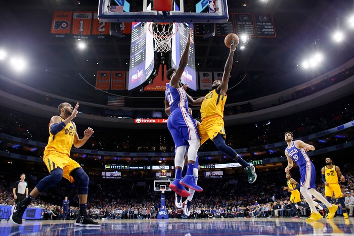 Utah Jazz's Royce O'Neale (23) goes up to shoot against Philadelphia 76ers' Joel Embiid (21) during the first half of an NBA basketball game, Monday, Dec. 2, 2019, in Philadelphia. (AP Photo/Matt Slocum)