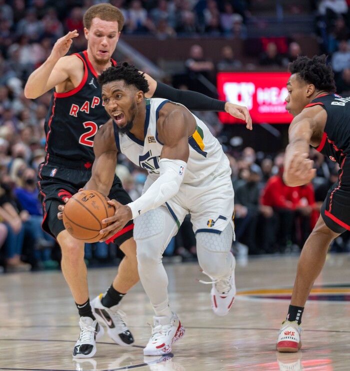 (Rick Egan | The Salt Lake Tribune) Utah Jazz guard Donovan Mitchell (45) splits his defends as he goes fo the hoop, in NBA action between Utah Jazz and Toronto Raptors, at Vivint Arena, in Salt Lake City, on  Thursday, Nov. 18, 2021.