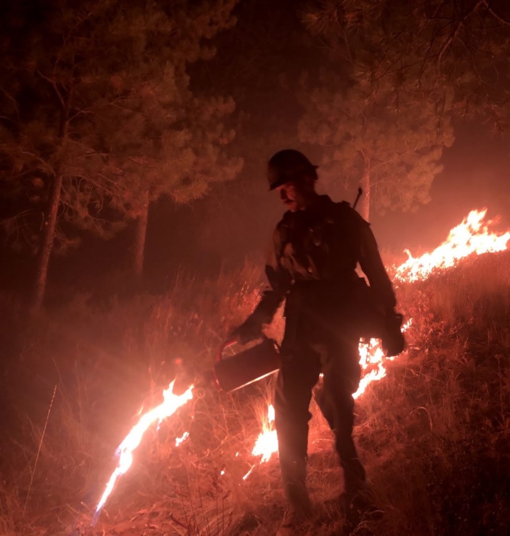 (Photo courtesy of Writers on the Range)  Harrison Raine sets backfire to stop a wildfire from spreading.