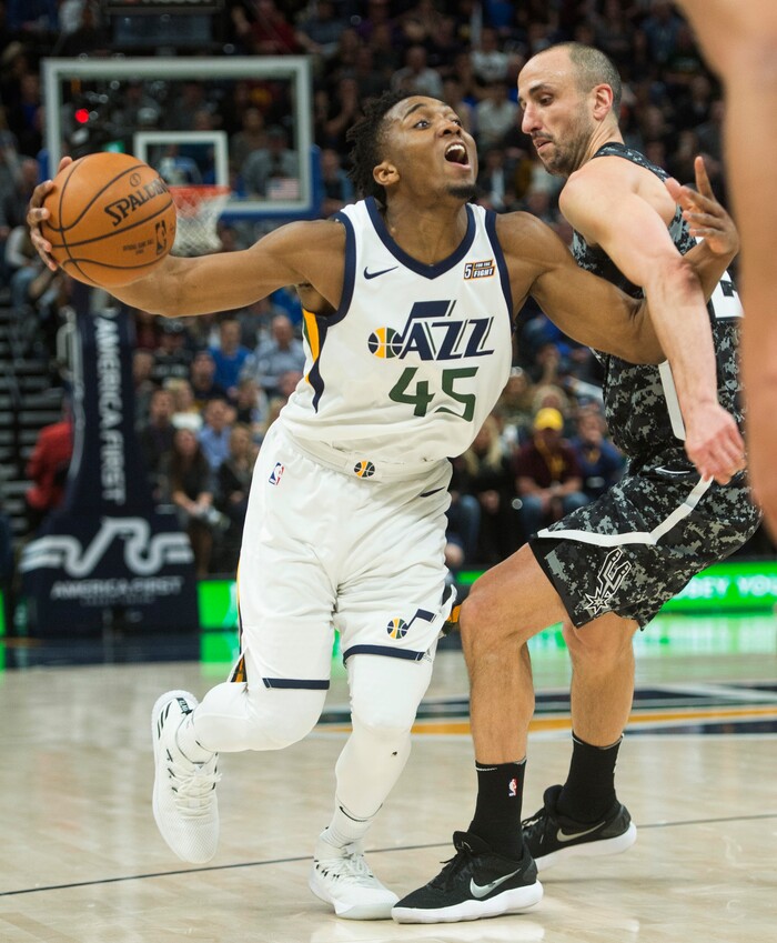 (Rick Egan  |  The Salt Lake Tribune)   Utah Jazz guard Donovan Mitchell (45) is fouled by San Antonio Spurs guard Manu Ginobili (20), in Salt Lake City, Monday, February 12, 2018.