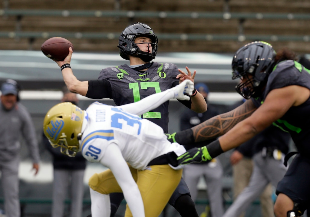 (Chris Pietsch | AP) Oregon's Tyler Shough throws down field under pressure from UCLA's Elisha Guidry during the second quarter of an NCAA college football game Saturday, Nov. 21, 2020, in Eugene, Ore.