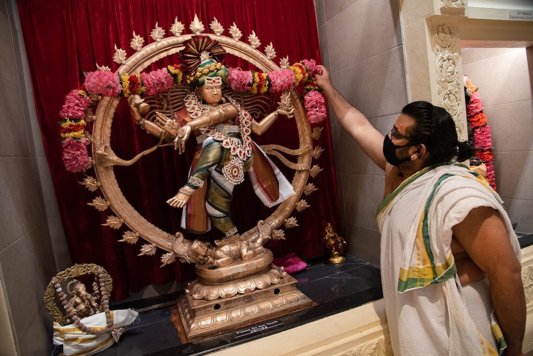 (Francisco Kjolseth  |  The Salt Lake Tribune) Hindu priest Sathish Nivarthi adjusts the Sri Nataraja shrine, a form of Shiva dancing on a demon of darkness meant to quell the beast at the Sri Ganesha Hindu Temple in South Jordan on Thursday, Sept. 26, 2020. As a way tp stay safe and cope during coronavirus pandemic, the temple is closed during weekdays, but priests go in in the evenings to decorate the statues and give offerings while broadcasting live classes and services online.