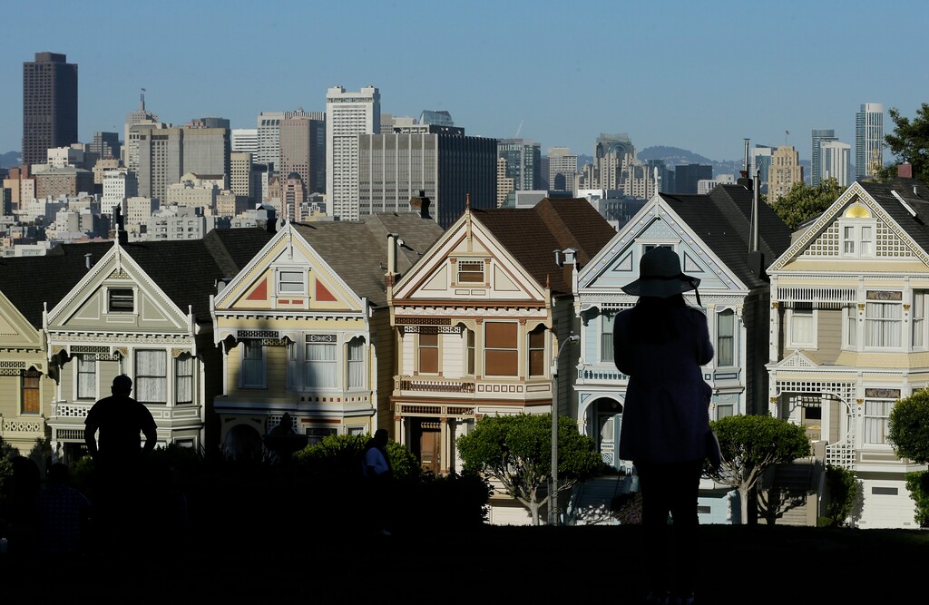 (Jeff Chiu | AP file photo)

In this April 15, 2016, photo, a woman looks toward the "Painted Ladies," a row of historical Victorian homes, with the San Francisco skyline at rear at Alamo Square Park in San Francisco.