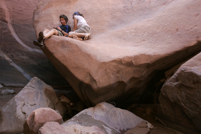 (Jim Urquhart | Tribune file photo) Aubriana Fumagali, 15, of Boca Raton, Florida, left, and Mary Baker, 15, of Washington DC., talk while resting on a ledge at the bottom of Coyote Gulch Thursday, July 31, 2008.