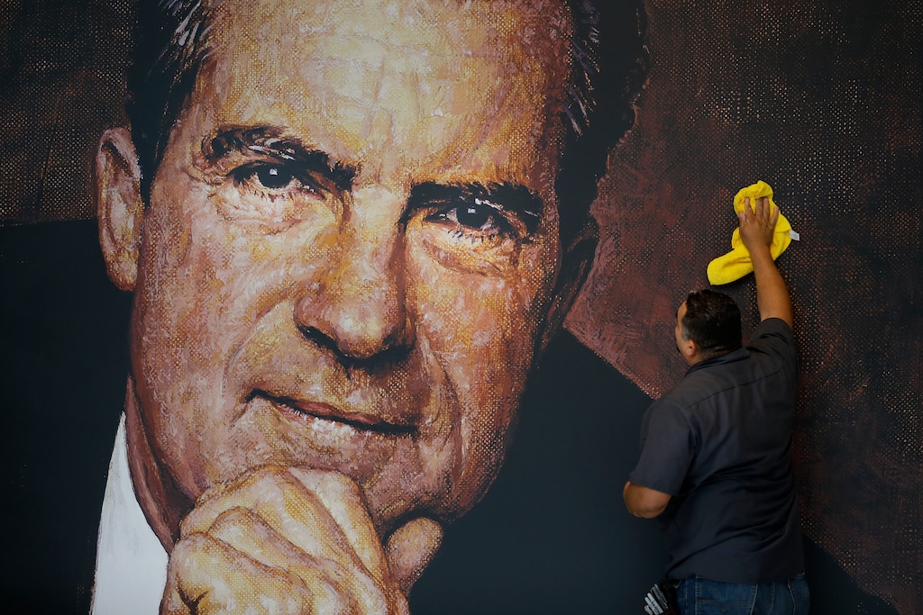 In this Wednesday, Oct. 5, 2016, photo, Tayron Santos cleans the newly installed wall mural of former President Richard Nixon in the lobby area of the Richard Nixon Presidential Library and Museum in Yorba Linda, Calif. (AP Photo/Jae C. Hong)