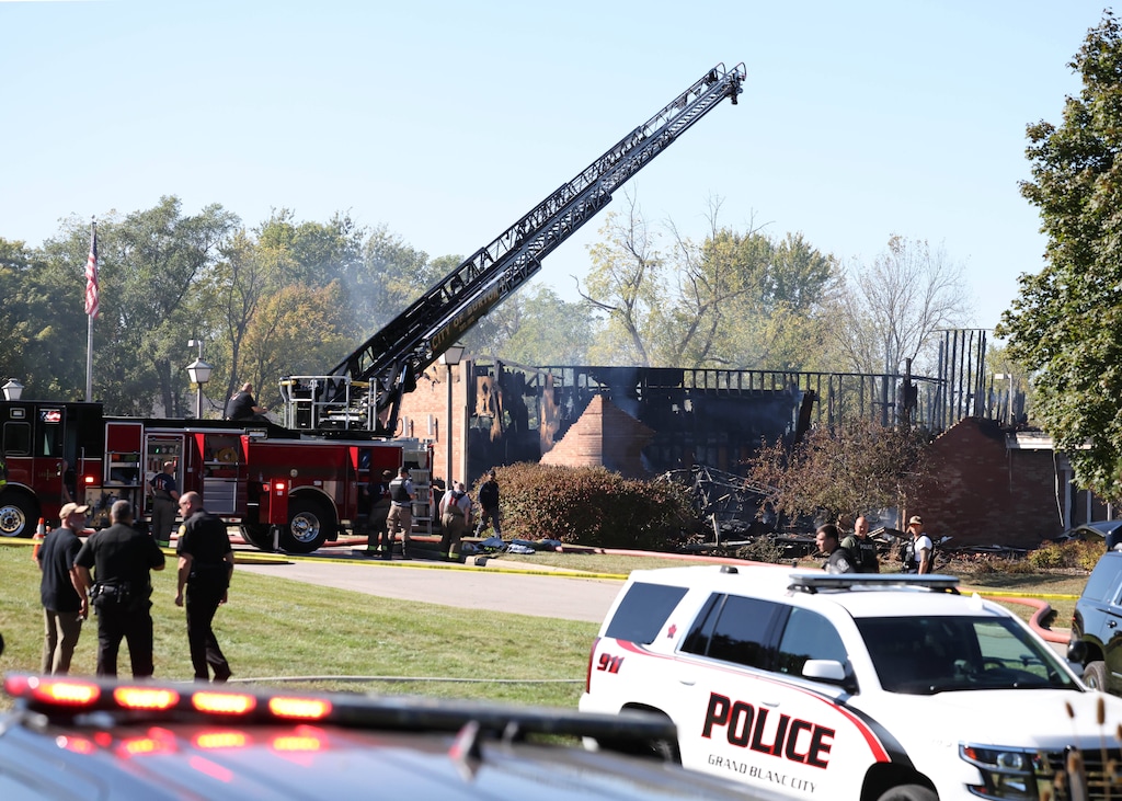 (Carlos Osorio | AP) Fire and law enforcement officers stand outside a Latter-day Saint meetinghouse that came under attack in Grand Blanc, Michigan. Church leaders are reiterating their safety guidelines.