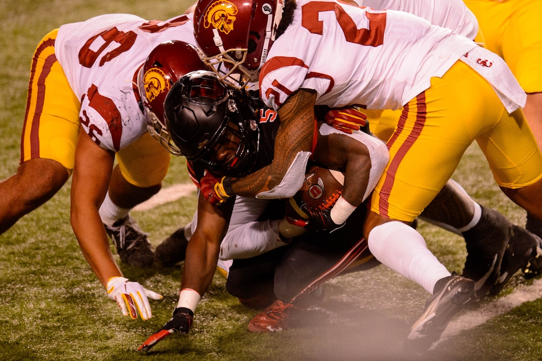 (Trent Nelson  |  The Salt Lake Tribune) Utah Utes running back Jordan Wilmore (5) is wrapped up by USC defenders, as the Utah Utes host the USC Trojans, NCAA football at Rice-Eccles Stadium in Salt Lake City on Saturday, Nov. 21, 2020.