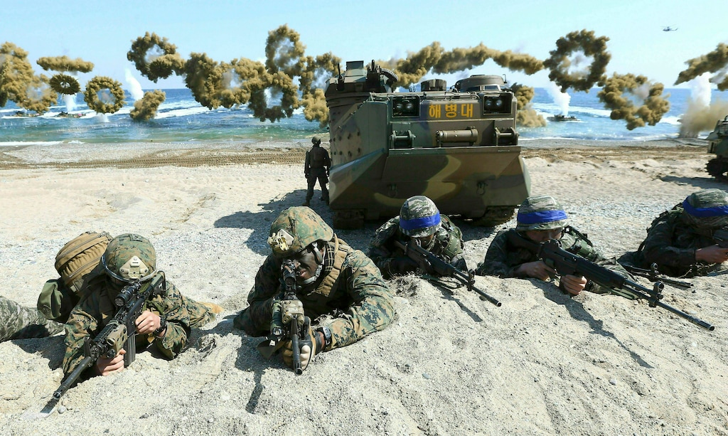 (Kim Jun-bum/Yonhap via AP) In this March 12, 2016, file photo, Marines of the U.S., left, and South Korea, wearing blue headbands on their helmets, take positions after landing on a beach during the joint military combined amphibious exercise, called Ssangyong, part of the Key Resolve and Foal Eagle military exercises, in Pohang, South Korea. South Korea and the U.S. say they've decided to end their springtime military drills to back diplomacy with North Korea.