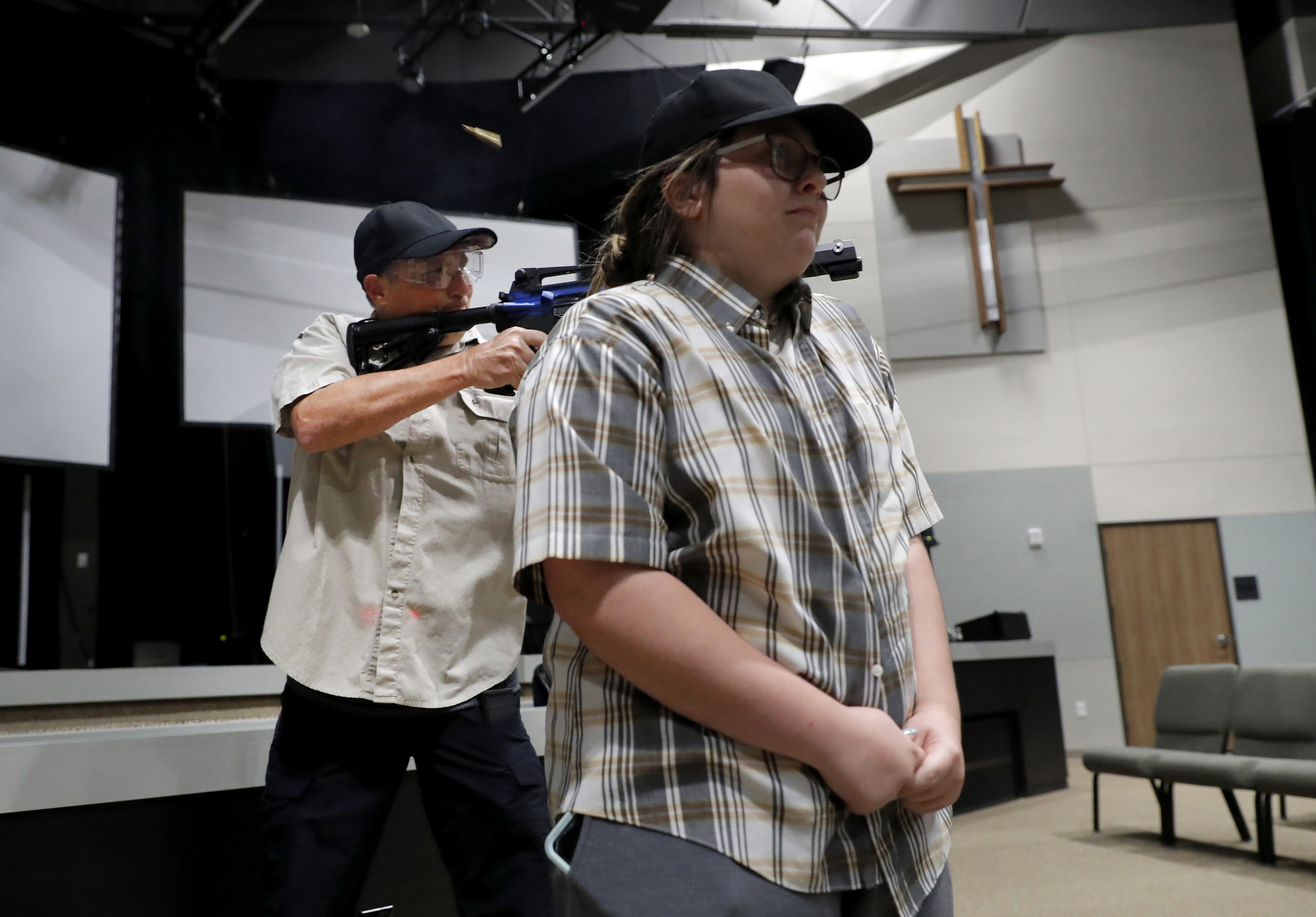 (Tony Gutierrez | AP Photo) In this July 21, 2019 photo, Brett Faulkner, left, fires blanks out of an assault rifle as he and Julia Gant, right, participate in a hostage-taking scenario during a security training session at Fellowship of the Parks campus in Haslet, Texas. An industry has sprung up following mass shootings at houses of worship around the country to train civilians to protect their churches with the techniques and equipment of law enforcement.