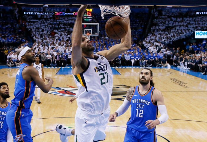 Utah Jazz center Rudy Gobert (27) dunks between Oklahoma City Thunder forward Corey Brewer, left, and center Steven Adams (12) during the first half of Game 5 of an NBA basketball first-round playoff series in Oklahoma City, Wednesday, April 25, 2018. (AP Photo/Sue Ogrocki)