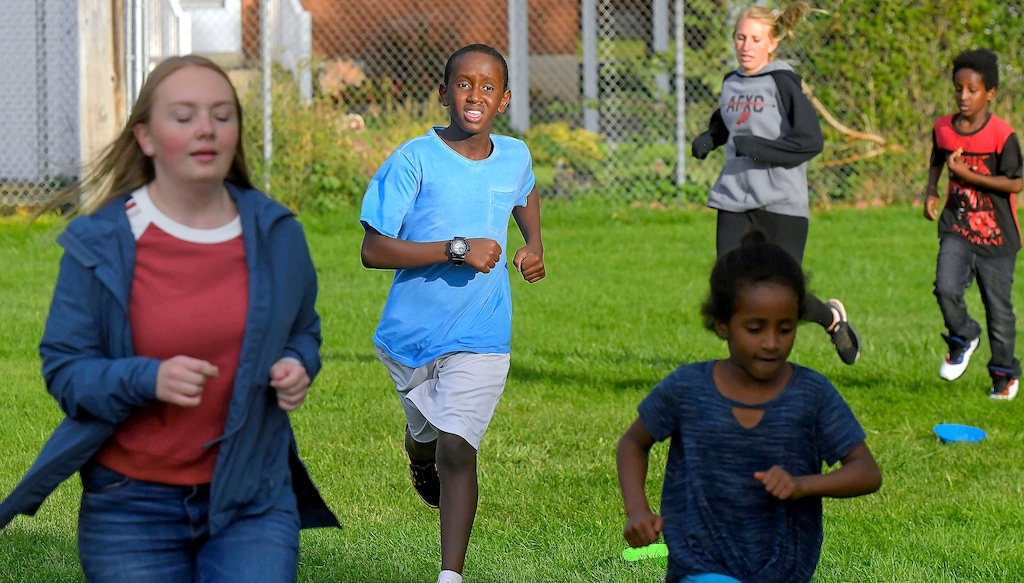 (Eli Lucero | The Herald Journal via AP) In this Sept. 11, 2019, photo Salman Yusuf, second from left, and others run laps on the field at Ellis Elementary School in Logan, Utah. Yusuf, who is a refugee from Somalia, is one of many kids who participate in the after school running club.