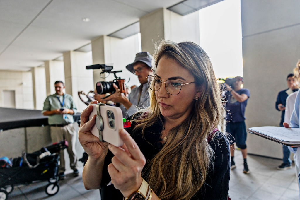 (Kim Raff/The New York Times) Keli Rabon, a podcaster from Houston, films outside the courthouse on the first day of a pre-trial hearing for Tyler Robinson, who was charged with killing Charlie Kirk.