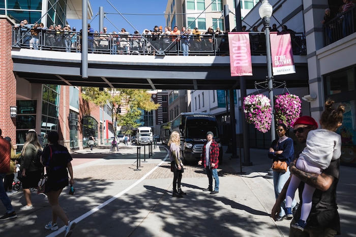 (Clark Clifford  |  Special to The Salt Lake Tribune) Spectators fill bridges while others smoke prior to Kanye West's Sunday Service at The Gateway in Salt Lake City on Saturday, Oct. 5, 2019.