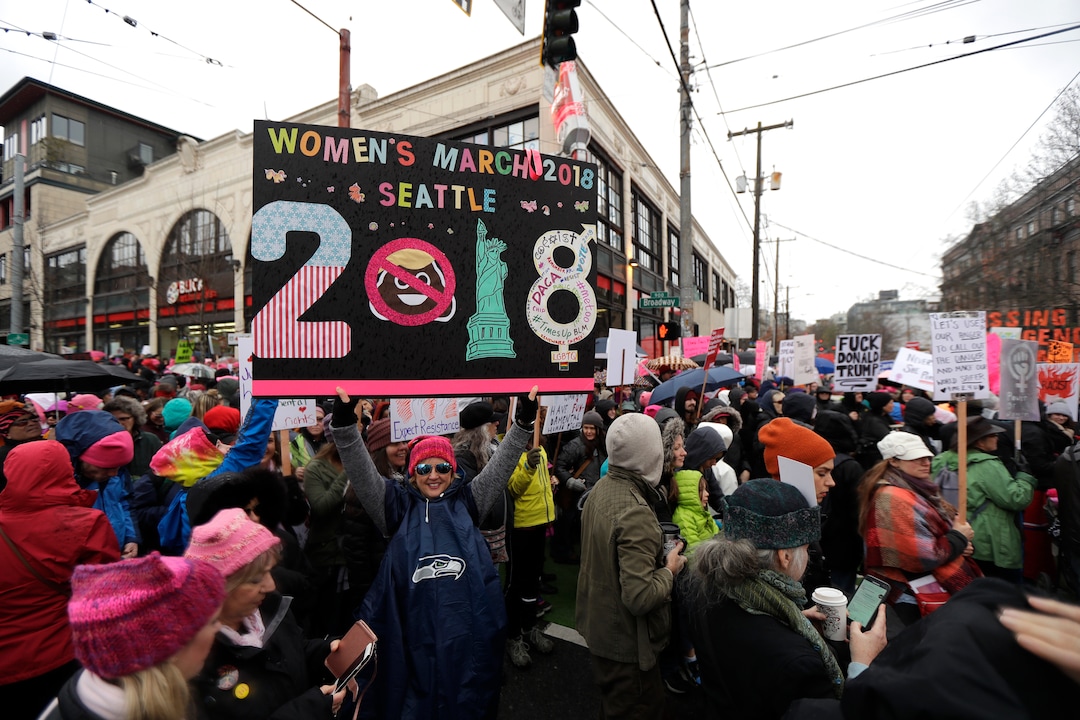 A woman holds as sign as she takes part in a Women's March in Seattle, Saturday, Jan. 20, 2018. The march was one of dozens planned across the U.S. over the weekend. (AP Photo/Ted S. Warren)