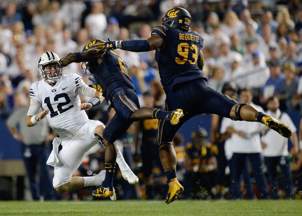 (Francisco Kjolseth | The Salt Lake Tribune) Brigham Young Cougars quarterback Tanner Mangum (12) gets rid of the ball as California barrels down on him during the first half of the NCAA college football game, Saturday, Sept. 8, 2018, at LaVell Edwards stadium in Provo, Utah.