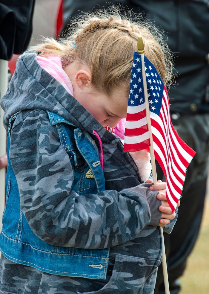 (Rick Egan  |  The Salt Lake Tribune)     Ruthann Reed, 7, bows her head during the dedicatory prayer, at the graveside service for 2nd Lt. Lynn W. Hadfield, who was killed during the Second World War, at Veterans Memorial Park, in Bluffdale. Thursday, March 21, 2019.


