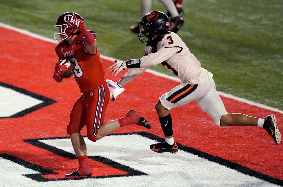 Utah wide receiver Britain Covey (18) scores against Oregon State defensive back Jaydon Grant (3) during the second half of an NCAA college football game Saturday, Dec. 5, 2020, in Salt Lake City. (AP Photo/Rick Bowmer)