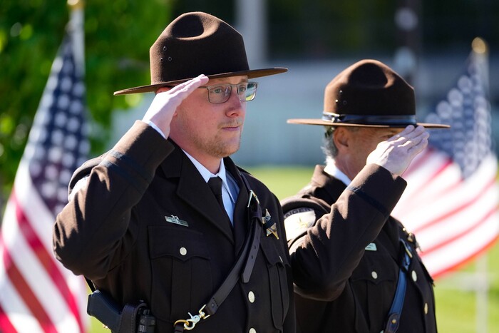 (Francisco Kjolseth  |  The Salt Lake Tribune) Officers salute the arrival of the hearse containing the body of Santaquin police Sgt. Bill Hooser at the UCCU Center at Utah Valley University on Monday, May 13, 2024.