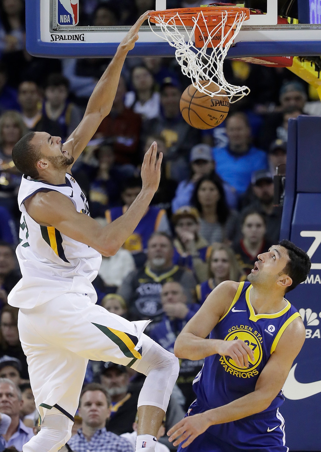 Utah Jazz center Rudy Gobert, left, dunks against Golden State Warriors center Zaza Pachulia during the first half of an NBA basketball game in Oakland, Calif., Sunday, March 25, 2018. (AP Photo/Jeff Chiu)