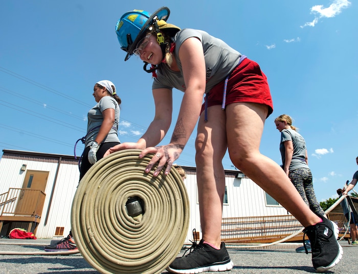 (Rick Egan  |  The Salt Lake Tribune)  Shelby rolls up a firehouse, while attending Camp Fury.  A dozen Utah Girl Scouts participated in a 3-day camp led by female firefighters. Camp Fury Utah was developed in partnership with the Girl Scouts and local fire and police departments, designed to expose teen girls to careers in public safety and other non-traditional jobs. Saturday, August 5, 2017.


