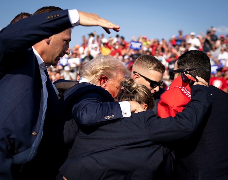 (Doug Mills | The New York Times) Secret Service agents surround former President Donald Trump after being shot during a campaign rally in Butler, Pa., on Saturday, July 13, 2024.