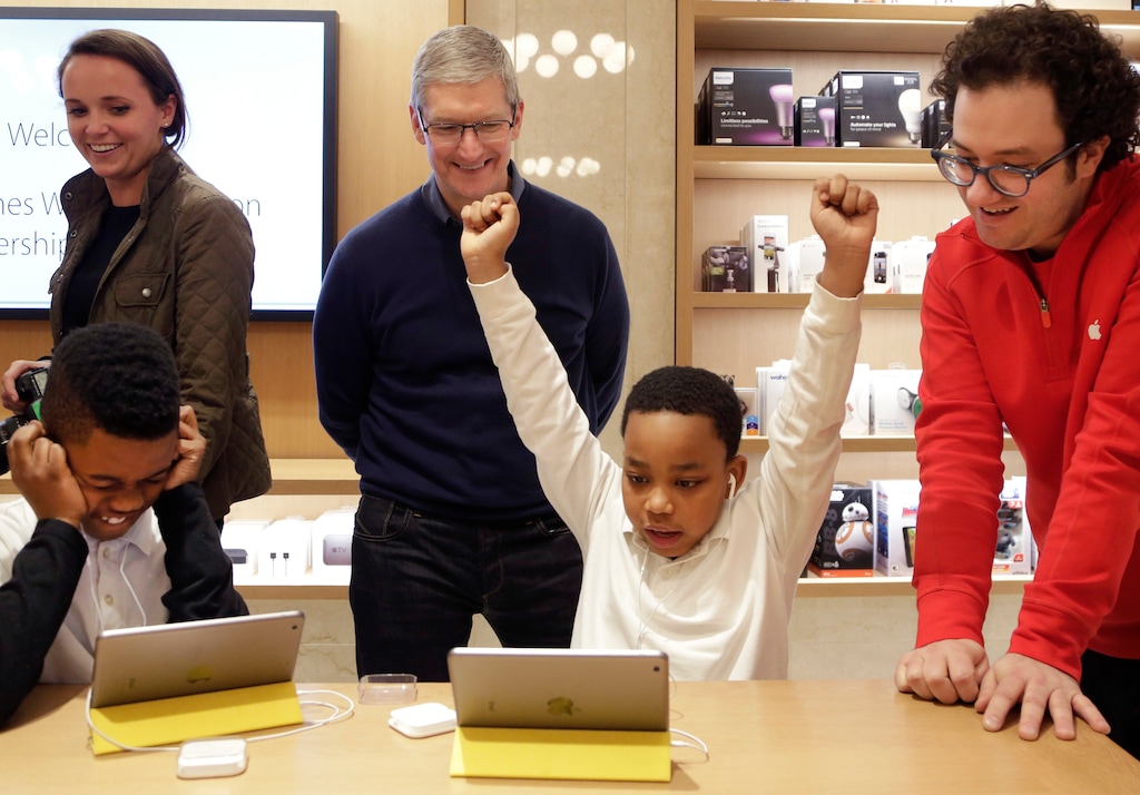 FILE - In this Wednesday, Dec. 9, 2015, file photo, third-grader Jaysean Erby raises his hands as he solves a coding problem as Apple CEO Tim Cook watches from behind during a coding workshop at an Apple Store, in New York. Theres a nationwide push to improve computer literacy in elementary school, and entrepreneurs are jumping aboard. You really want kids to learn these building blocks as young as possible and then build on them, said Cook. (AP Photo/Mark Lennihan, File)