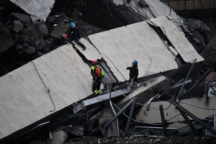 Rescues work among the debris of the collapsed Morandi highway bridge in Genoa, Tuesday, Aug. 14, 2018. Italian authorities say that about 10 vehicles were involved when the raised highway collapsed during a sudden and violent storm in the northern port city of Genoa, while private broadcaster Sky TG24 said the collapsed section was about 200-meter long (650 feet). (Luca Zennaro/ANSA via AP)