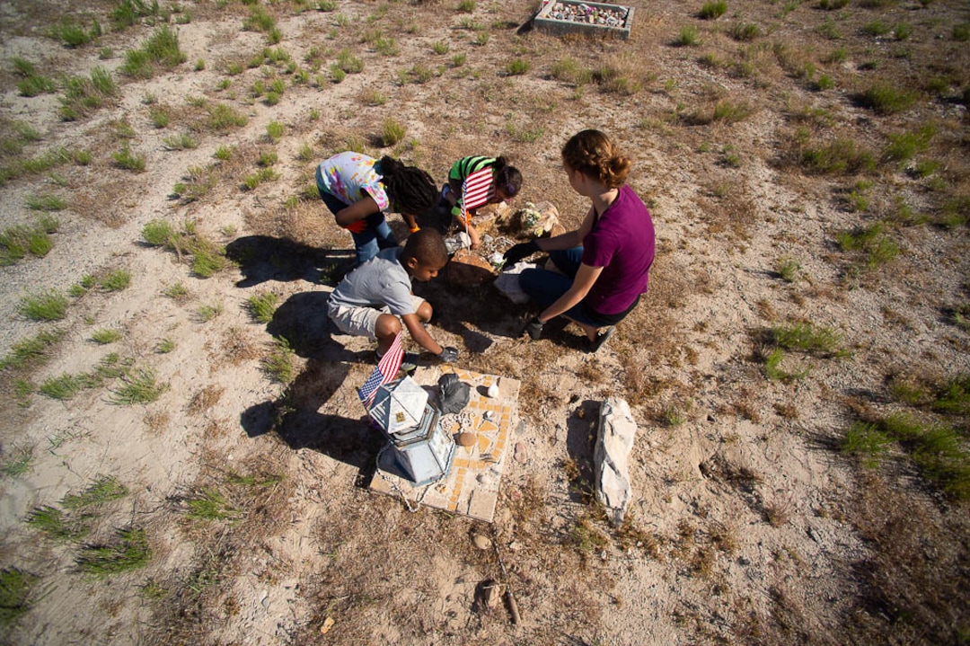 (Trent Nelson | The Salt Lake Tribune)  Descendants of the Hawaiians who settled the desert town of Iosepa took time during their Memorial Day gathering to clean the graves of their ancestors, Saturday May 26, 2018.   Garrett Crook, Sariah Crook, Evaine Ha'o, and Lynnea Crook pull weeds from around a grave
