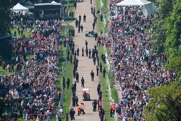 Spectators gather along the Long Walk ahead of the wedding of Prince Harry and Meghan Markle at Windsor castle in Windsor near London, England, Saturday May 19, 2018.  (Yui Mok/PA via AP)